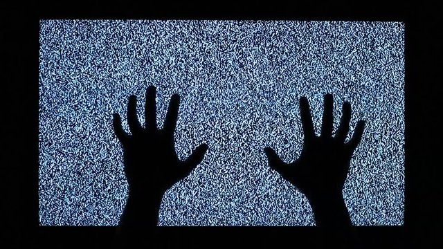 Video noise and black hands on television display. Two hands touch television screen