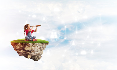 Concept of careless happy childhood with girl looking in spyglass