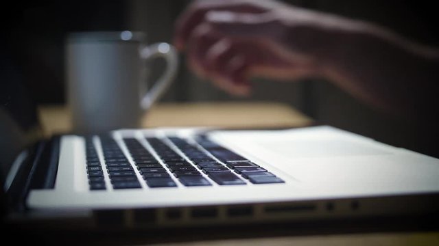 Working Nights Home Typing on Laptop with Tea in Coffee Cup