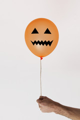 Halloween orange balloon with scary face