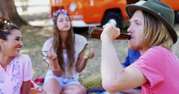 Man drinking beer with his friends at music festival 