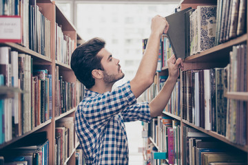 Side profile view of attractive brunet bearded student bookworm, studying in the ancient school...