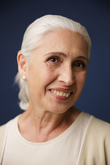 Close-up portrait of cheerful old woman looking at camera