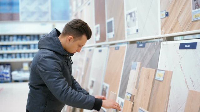 Man is Choosing Building Material in a Construction Shop for a New House