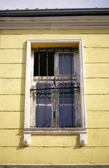 Obraz premium Old window on a yellow facade.