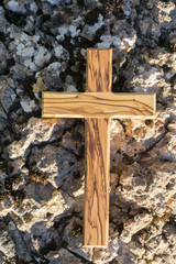 Holzkreuz liegt auf zerklüftetem Boden