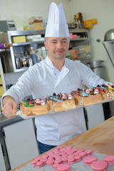 pastry chef holding delicious looking cakes and pastries