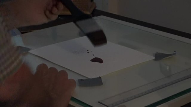 man photographer working in darkroom with photographs hanging to dry