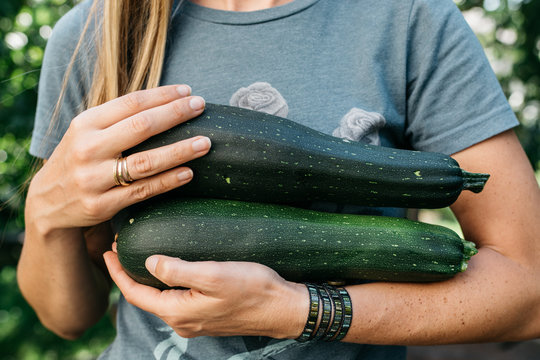Woman holding two zucchini