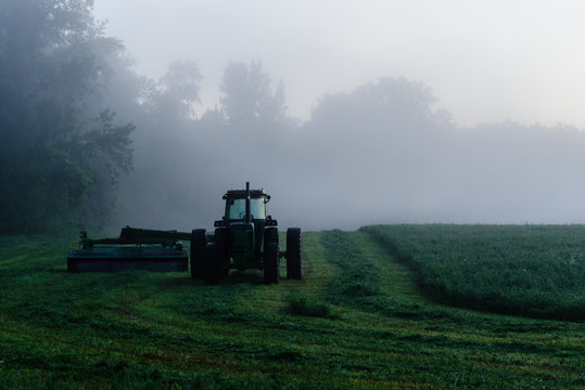 Fototapeta tractor hiding in the early morning mist
