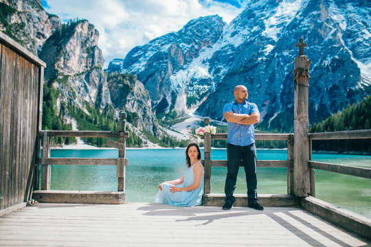  Man and woman on vacation in beautiful place mountains.Young couple in love on the pier at lake, lago di braies,Dolomite,Italy.