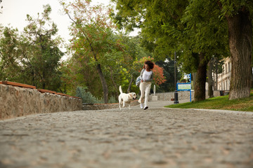 Fototapeta premium Funny healthy lady running in the morning with her dog in park