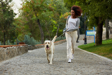 Funny healthy lady running in the morning with her dog in park