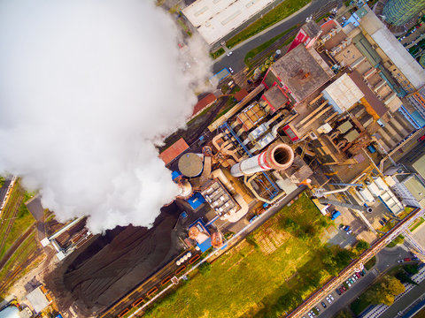 Aerial view to smoking chimmney from lignite power plant. Air pollution and climate change theme. Heavy industry from above. 