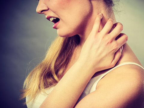 woman scratching her itchy neck with allergy rash