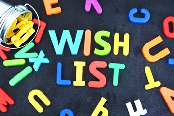 Wish list concept with colorful letters on blackboard pouring out from a metallic bucket