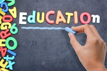 Education concept with colorful plastic letters on blackboard