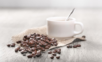 grains de café avec une tasse blanche
