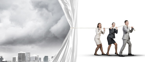 Young businesspeople working in collaboration and pulling white advertisement banner