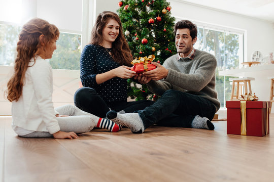 Young couple celebrating Christmas with their daughter.