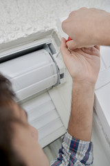 man repairing blinds