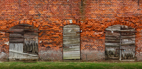 Fototapeta na wymiar Old bricks wall texture with doors and shutters.