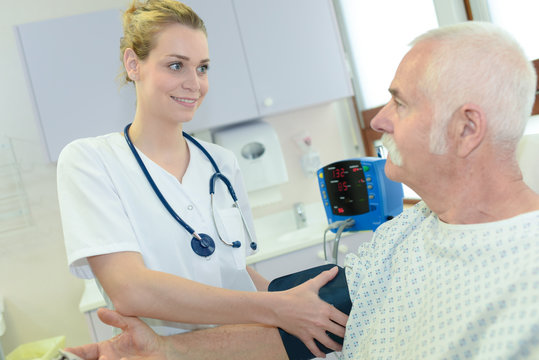 Nurse putting blood pressure testing cuff onto patient's arm