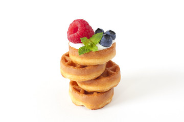 Pile of Belgian waffle with blueberry, raspberries and fresh mint Isolated