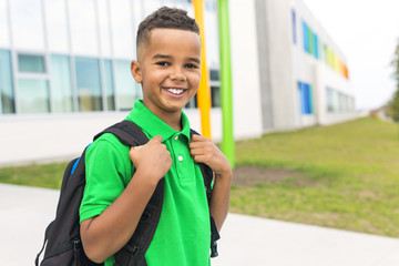 cheerful african american primary school boy with backpack