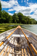 Fototapeta na wymiar Wooden Rowing boat on a lake in UK summer sun Shropshire UK