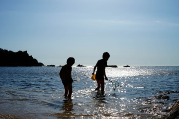 Fototapeta na wymiar 海で遊ぶ子供たち