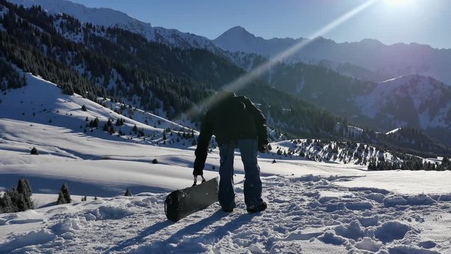 4k footage of successful snowboarder man adventure to winter mountain
