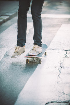 Skateboarder legs riding skateboard on the street