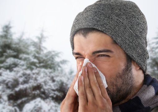 Man Blowing His Nose In Snow Forest