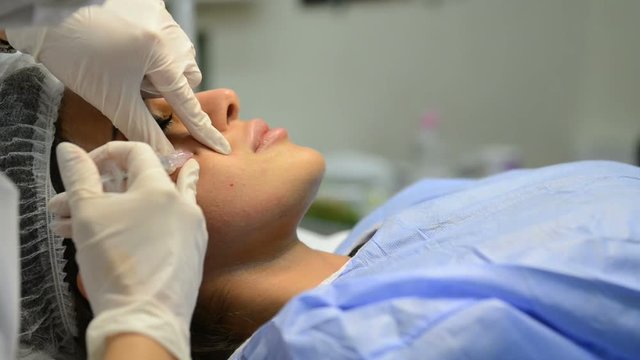 Young woman having a botox injection at beauty salon.
