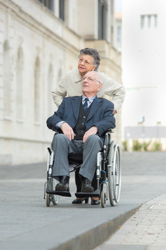senior couple in wheelchair enjoying a day in the city