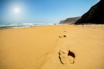 Footsteps in the sand at beach Praia do Vale dos Homens near Aljezur, Algarve Portugal