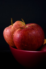 Apples in a red bowl