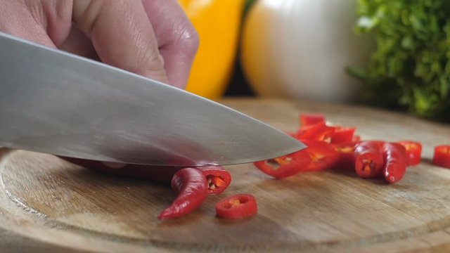Man's hands cutting red pepper.