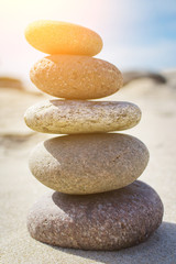 Pyramid of pebbles on sand toned