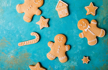  Ginger men with colored glaze on a turquoise background .. Gingerbread. Christmas cookies. Ginger man in a colored sweater.