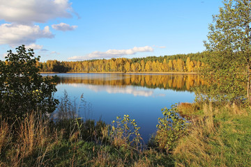 Lake in a delightful autumn forest at sunny day. Russia.