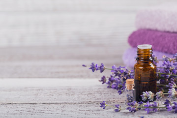 Fototapeta na wymiar Bottle of essential oil and fresh lavender flowers