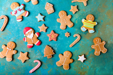 Fototapeta na wymiar Ginger men with colored glaze on a turquoise background .. Gingerbread. Christmas cookies. Ginger man in a colored sweater. Gingerbread Santa