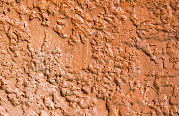 Rough red painted concrete wall. Bright rough plaster photo texture.