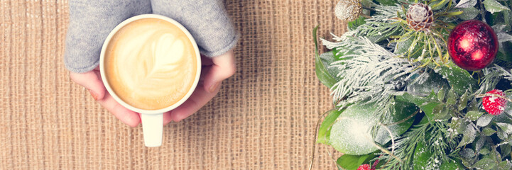 Girl holding cup of coffee with latte art. Leisure time concept. Pastel colors