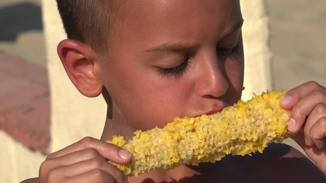 Boy eating fresh boiled corn