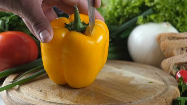 Men's hands cut out the middle of pepper