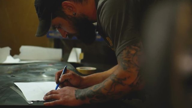 Artist in the workshop makes sketch of a drawing