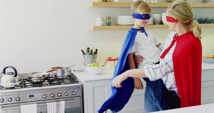 Mother and son pretending to be superhero in living room 